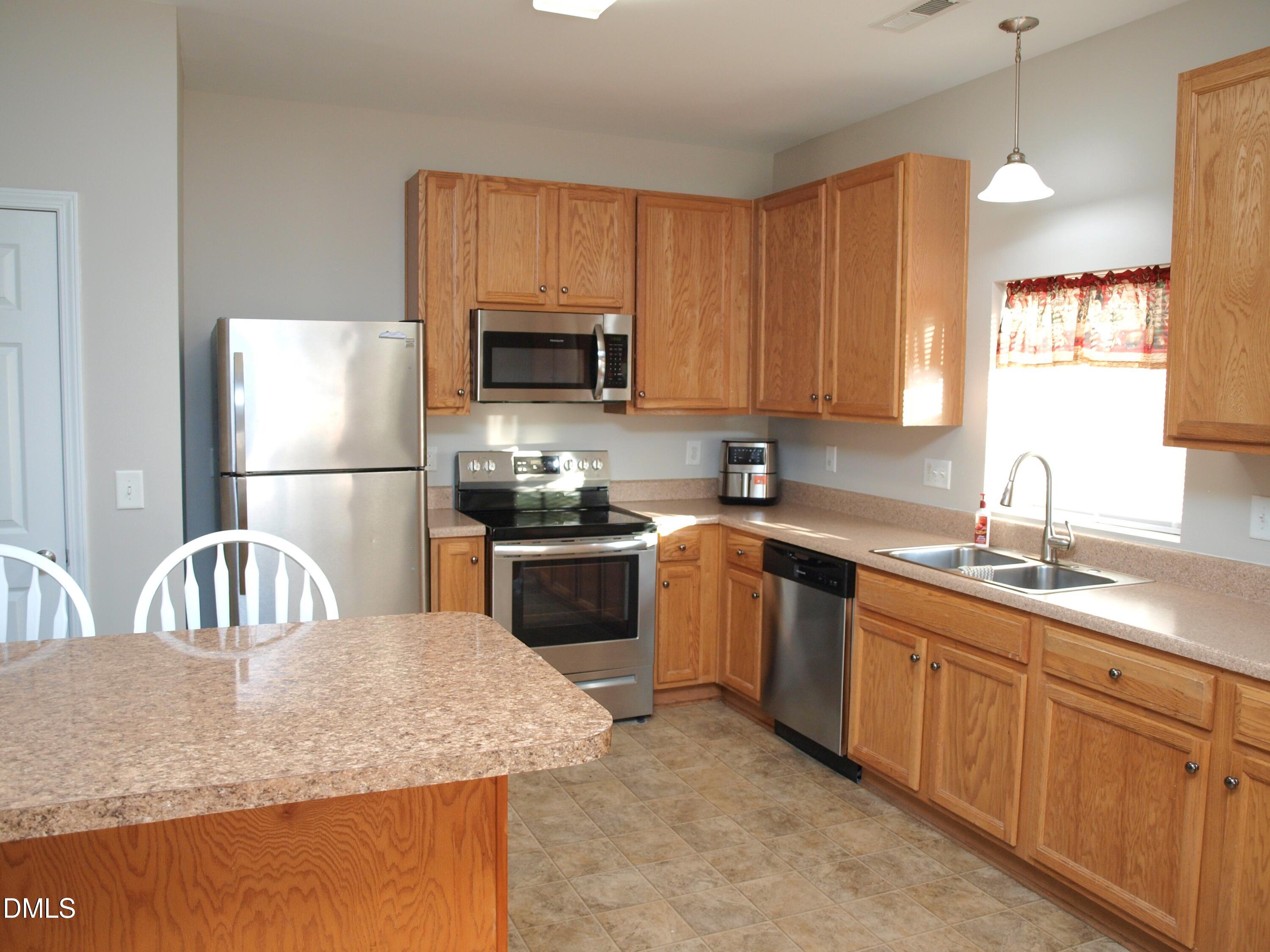 2019 Tennessee Road Durham, NC 27704 - Photo 8 of 21 a kitchen with granite countertop stainless steel appliances a sink a stove a microwave a sink a refrigerator and cabinets