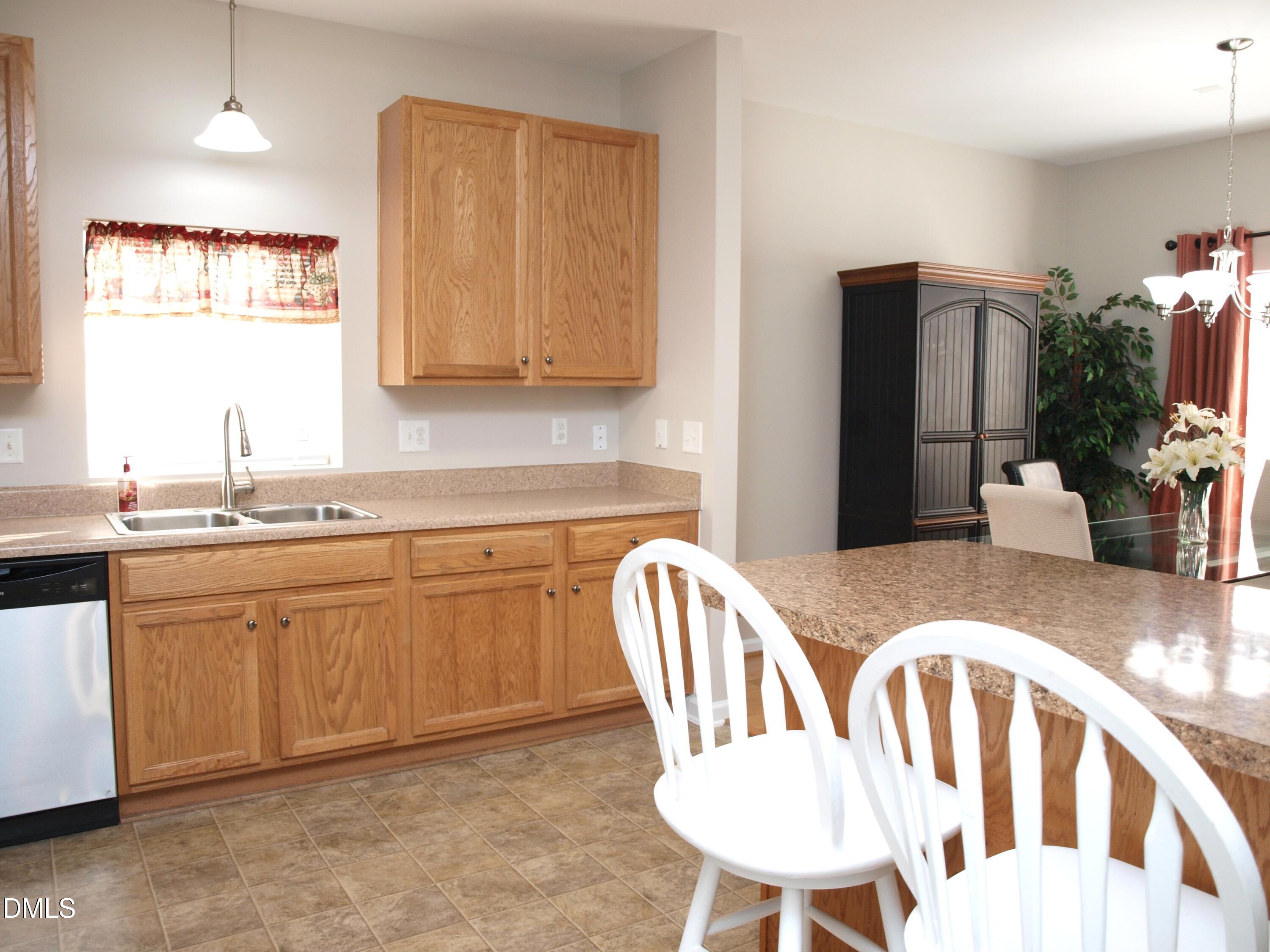 2019 Tennessee Road Durham, NC 27704 - Photo 10 of 21 a kitchen with stainless steel appliances granite countertop a dining table chairs and a refrigerator