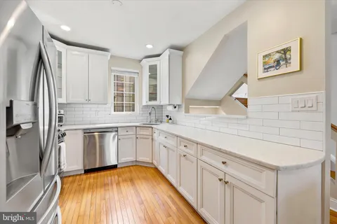 a kitchen with granite countertop a sink stove and cabinets
