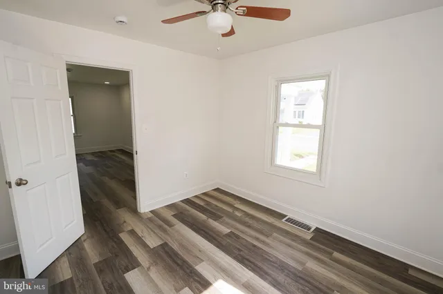 an empty room with wooden floor and closet