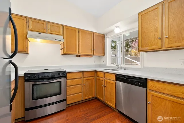 a kitchen with stainless steel appliances granite countertop a stove a sink and a microwave