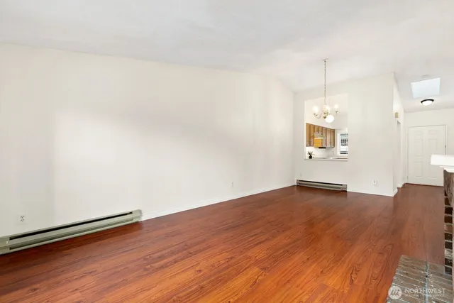 a view of a room with wooden floor and white walls
