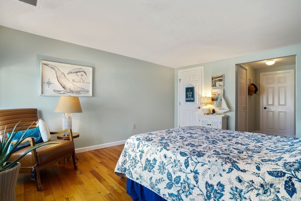 1 Commodore Court, Unit 104 Hull, MA 02045 - Photo 21 of 35 a bedroom with a bed and a chandelier