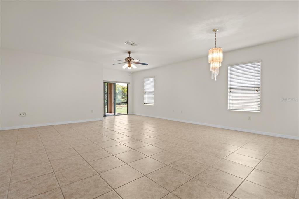 8932 Excelsior Place Venice, FL 34293 - Photo 13 of 43 an empty room with chandelier and white walls