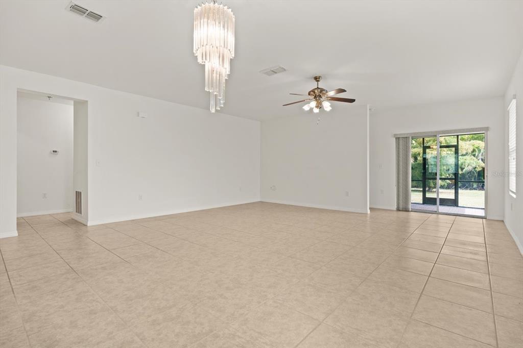 8932 Excelsior Place Venice, FL 34293 - Photo 14 of 43 an empty room with chandelier fan and windows
