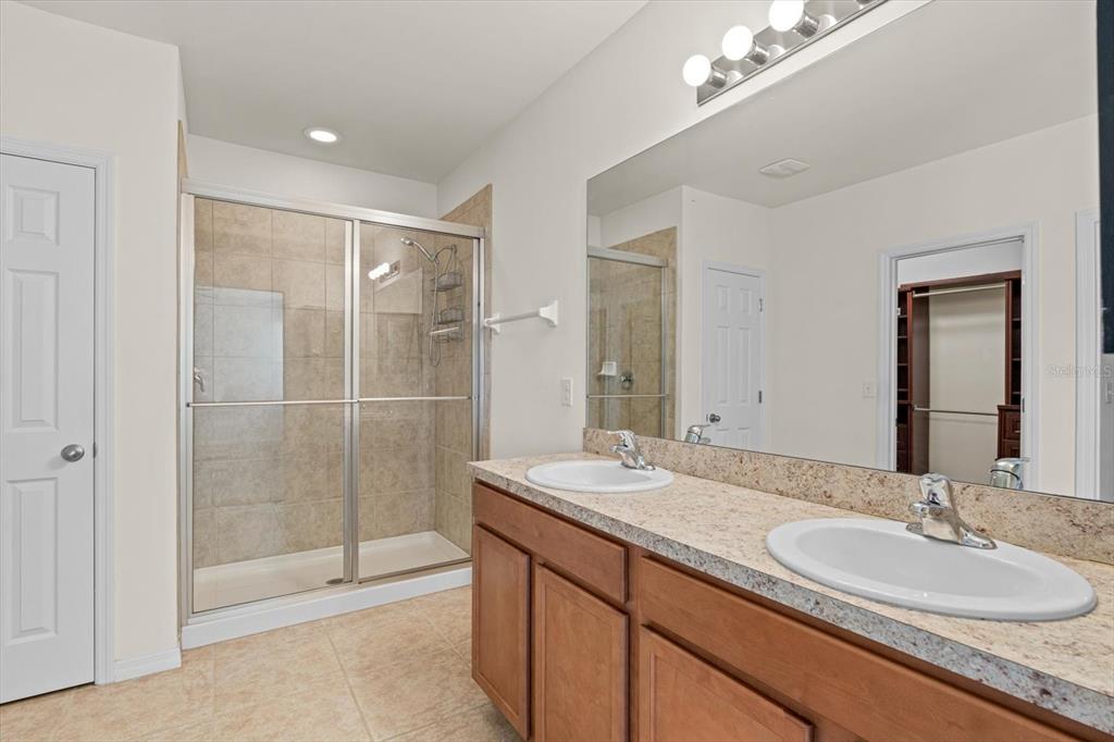 8932 Excelsior Place Venice, FL 34293 - Photo 18 of 43 a bathroom with a granite countertop double vanity sink mirror and shower