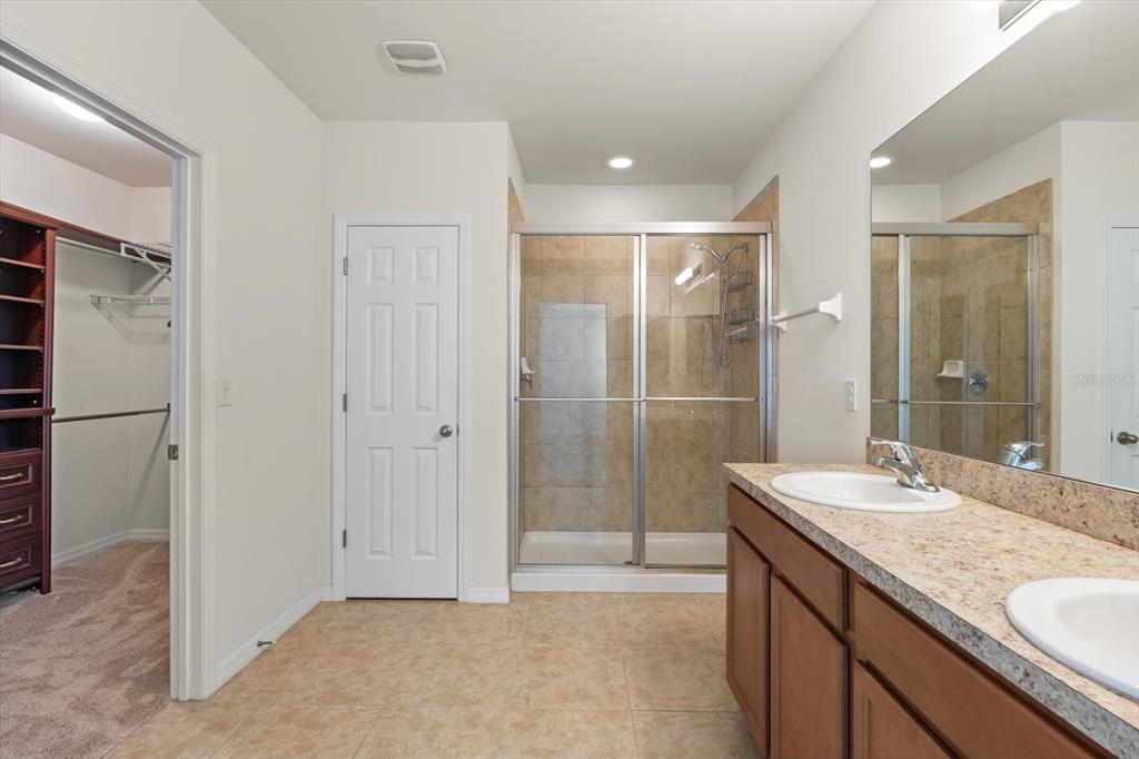 8932 Excelsior Place Venice, FL 34293 - Photo 19 of 43 a bathroom with a granite countertop sink a mirror and a shower