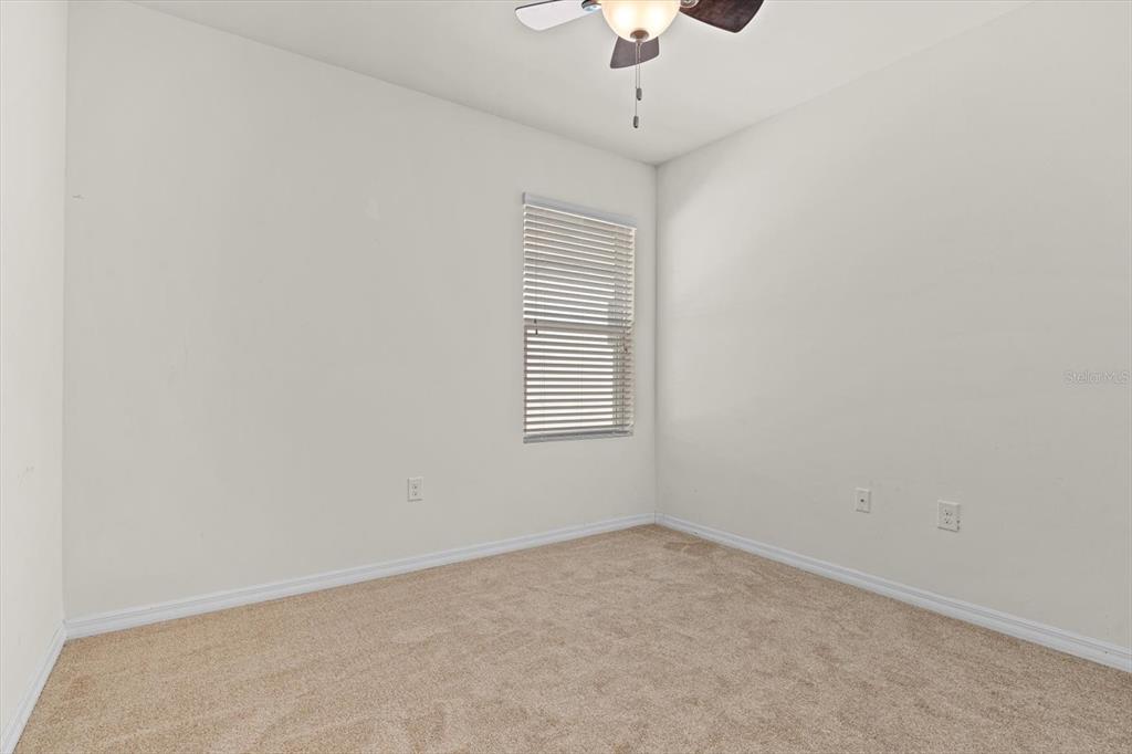 8932 Excelsior Place Venice, FL 34293 - Photo 22 of 43 an empty room with a chandelier fan and windows