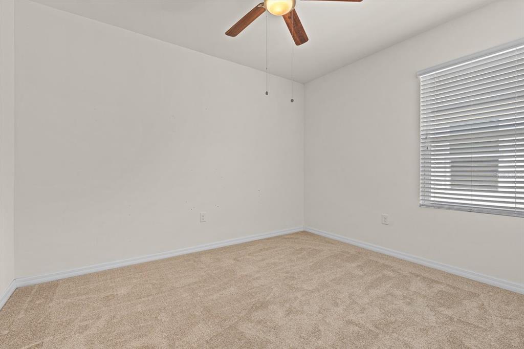 8932 Excelsior Place Venice, FL 34293 - Photo 26 of 43 an empty room with a window and a ceiling fan