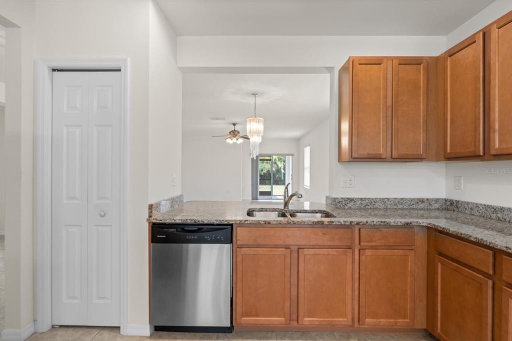 8932 Excelsior Place Venice, FL 34293 - Photo 9 of 43 a kitchen with granite countertop white cabinets and stainless steel appliances