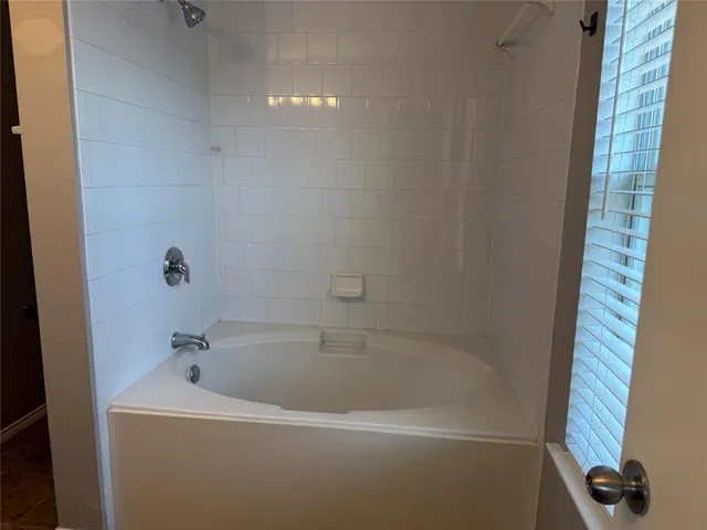 a white bath tub and shower in a bathroom