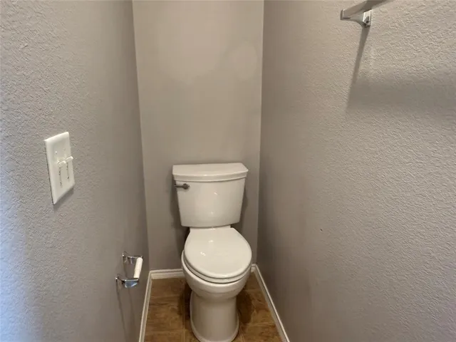 a white toilet sitting next to a white cabinet