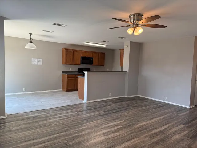 a view of a kitchen with a flat screen tv and wooden floor