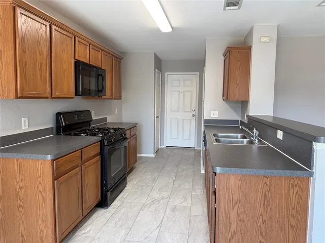 a kitchen with a sink and a stove top oven