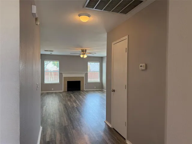 a view of a hallway with wooden floor and a fireplace