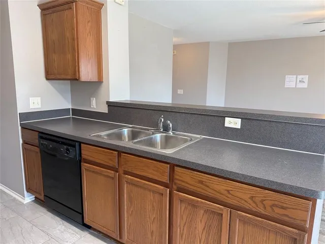 a kitchen with granite countertop a sink and cabinets