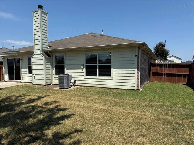 a view of house with backyard and trees