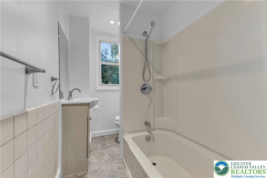 2246 2nd Street Wilson, PA 18042 - Photo 25 of 47 a white bath tub sitting next to a white sink and vanity