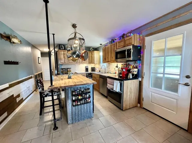 a kitchen that has a lot of white cabinets and stainless steel appliances