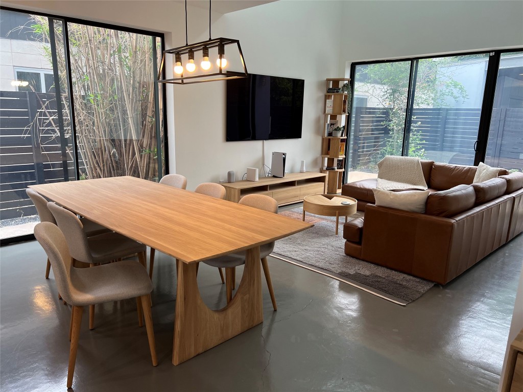 a living room with furniture a flat screen tv and a large window