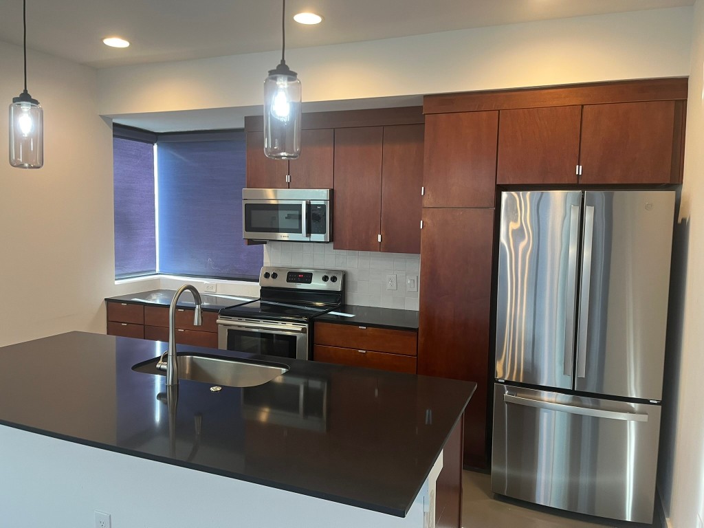 1105 Altum Street Austin, TX 78721 - Photo 4 of 16 a kitchen with kitchen island a counter space a sink and stainless steel appliances
