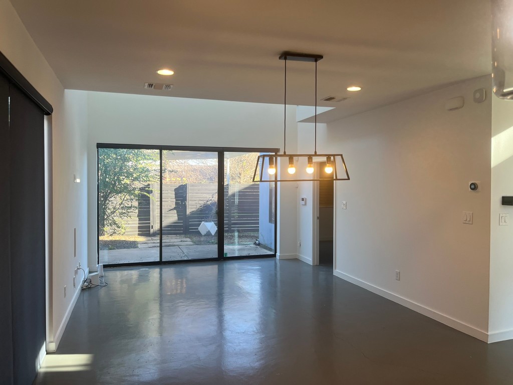 1105 Altum Street Austin, TX 78721 - Photo 5 of 16 a view of an empty room with wooden floor and a window