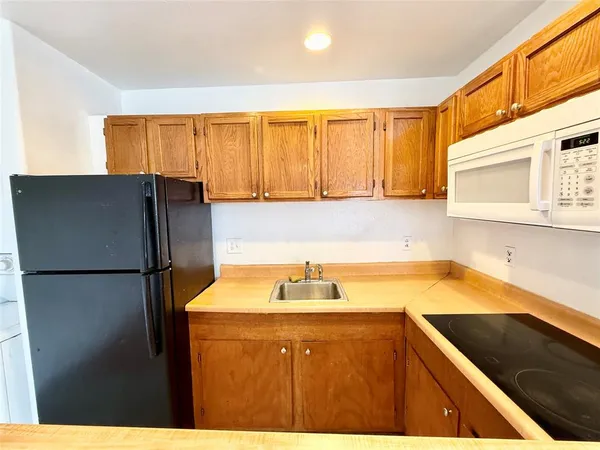 a kitchen with a refrigerator and a sink