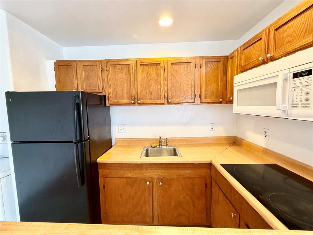 9839 Walnut Street, Unit 305 Dallas, TX 75243 - Photo 5 of 7 a kitchen with a refrigerator and a sink