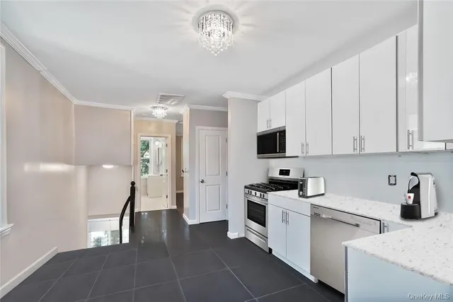 a kitchen with stainless steel appliances a white stove top oven a sink a refrigerator and cabinets