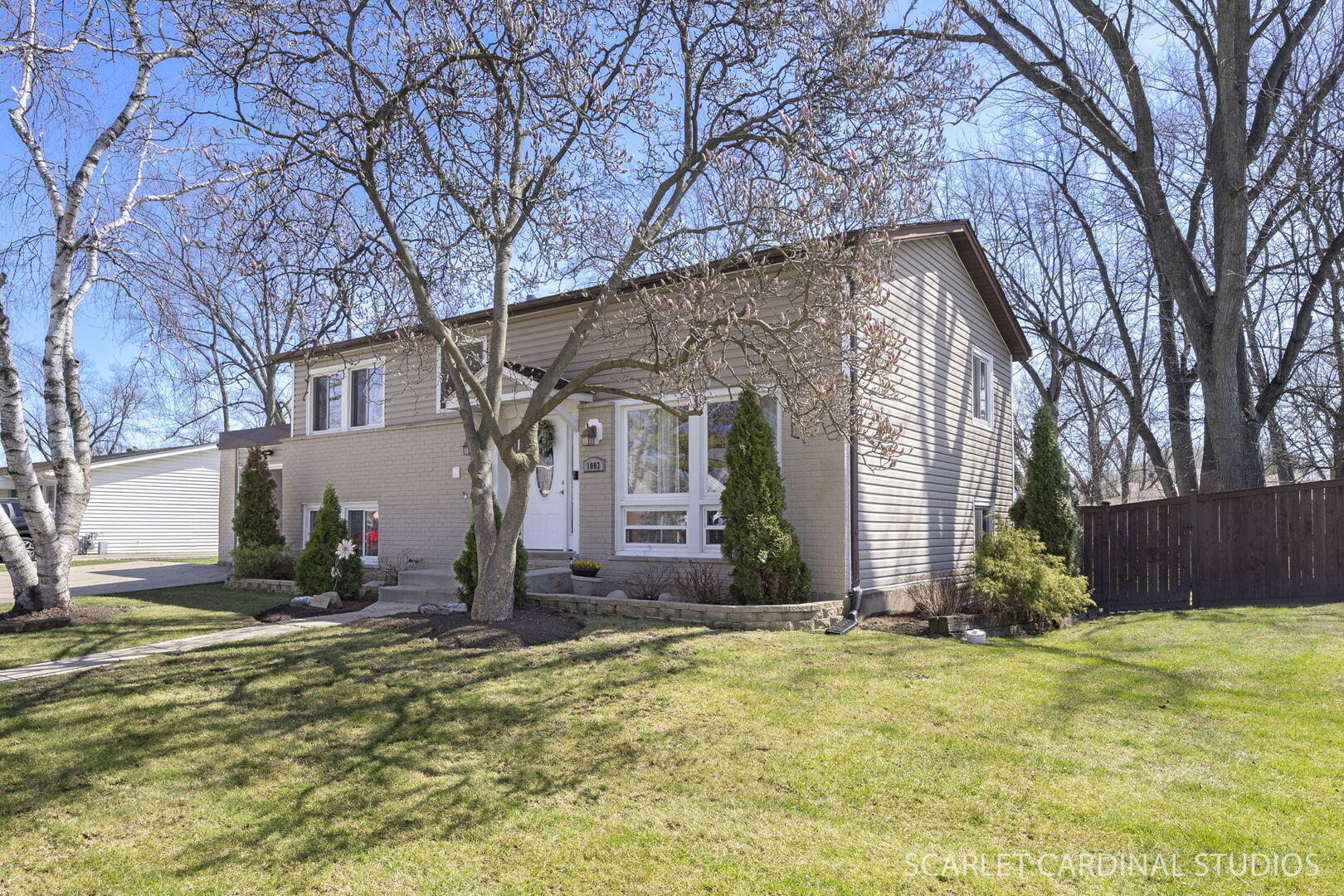 1003 East Alder Lane Mount Prospect, IL 60056 - Photo 2 of 35 a view of a brick house with large windows and a large tree