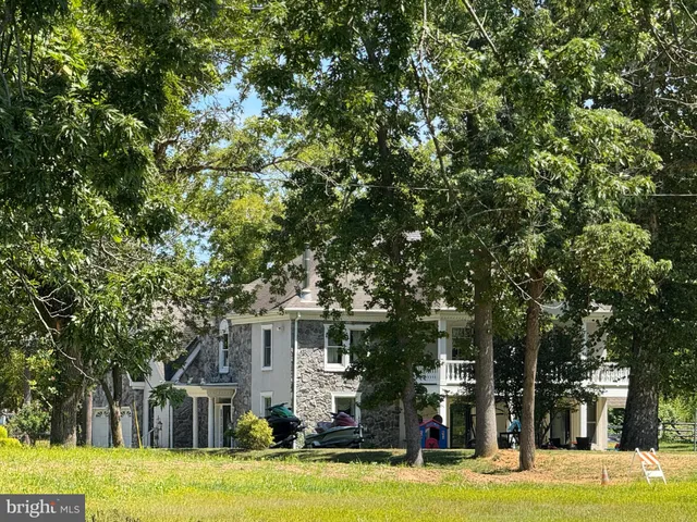 a kitchen with stainless steel appliances granite countertop wooden cabinets a stove top oven a granite counter space and a window