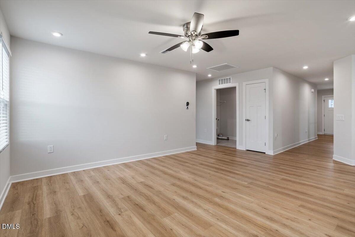 8588 Kenridge Lane Fuquay-Varina, NC 27526 - Photo 22 of 37 an empty room with wooden floor and a ceiling fan