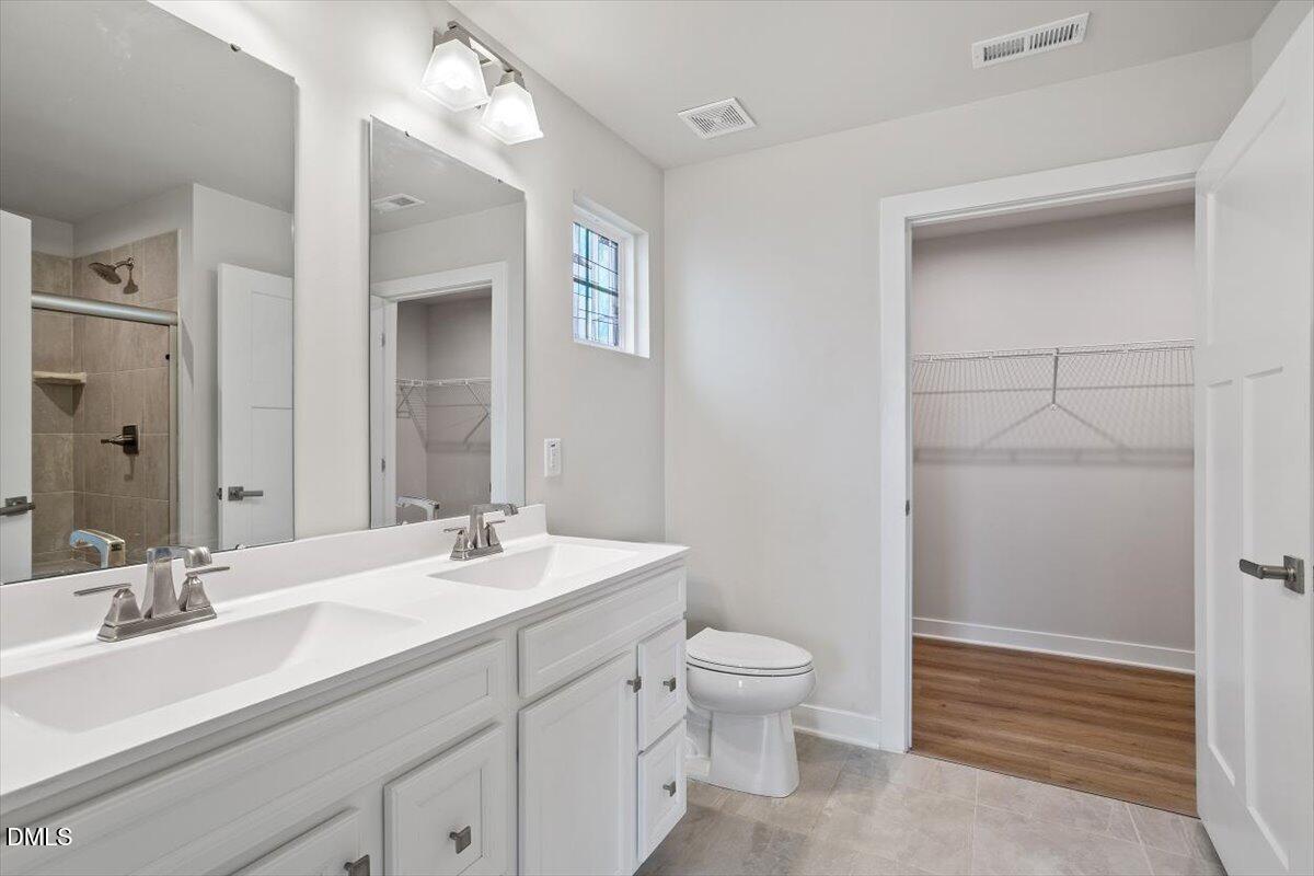 8588 Kenridge Lane Fuquay-Varina, NC 27526 - Photo 27 of 37 a bathroom with a sink a toilet and shower