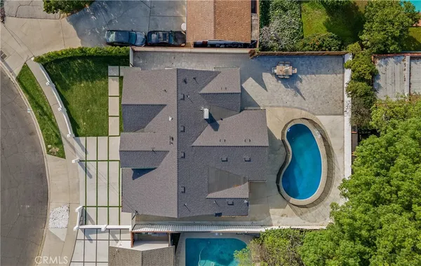 an aerial view of a house with outdoor space and swimming pool