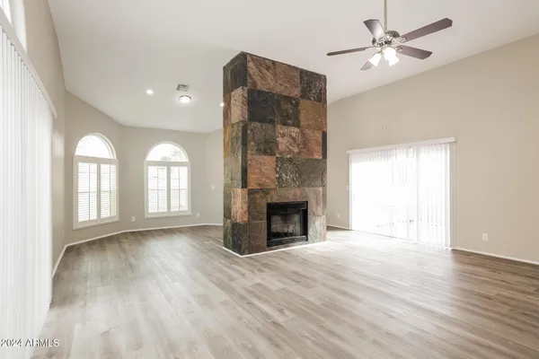 a view of an empty room with a fireplace and a window