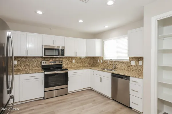 a kitchen with stainless steel appliances granite countertop a sink and stove top oven