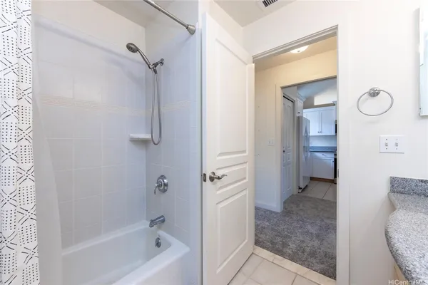 a bathroom with a granite countertop mirror vanity and a shower
