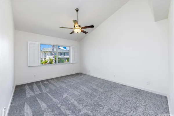 an empty room with windows and fan