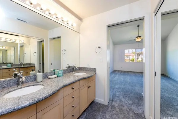a en suite bathroom with a granite countertop sink and a mirror