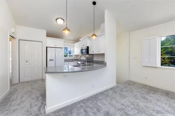 a kitchen with stainless steel appliances granite countertop a sink a refrigerator and a granite counter tops