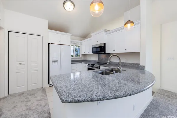 a kitchen with stainless steel appliances granite countertop a sink a refrigerator and a stove