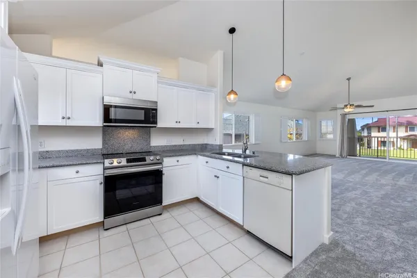 a kitchen with stainless steel appliances granite countertop a sink a stove and a refrigerator
