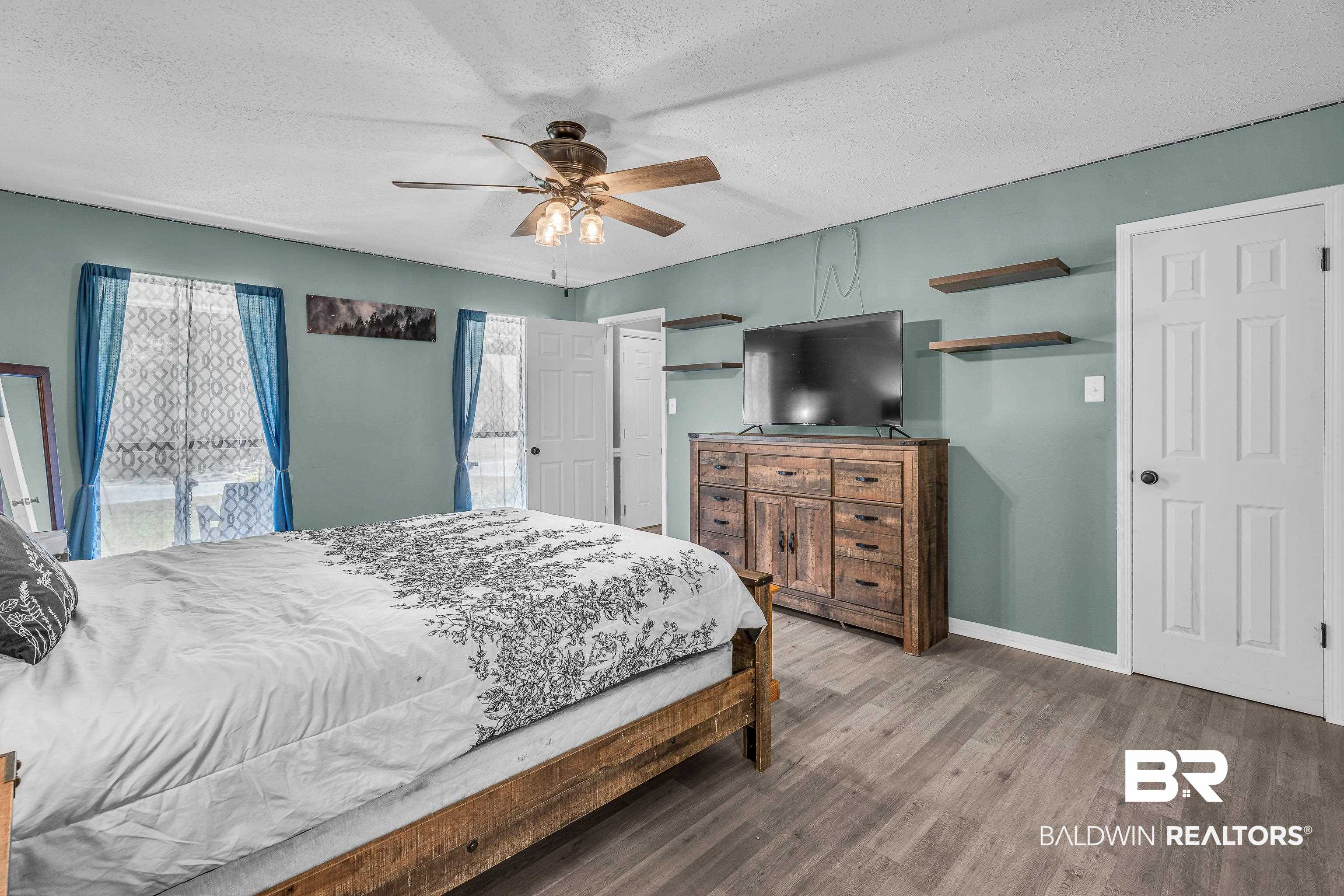 6135 Oak Cliff Drive Eight Mile, AL 36613 - Photo 18 of 30 Bedroom featuring a textured ceiling, wood finished floors, and a ceiling fan