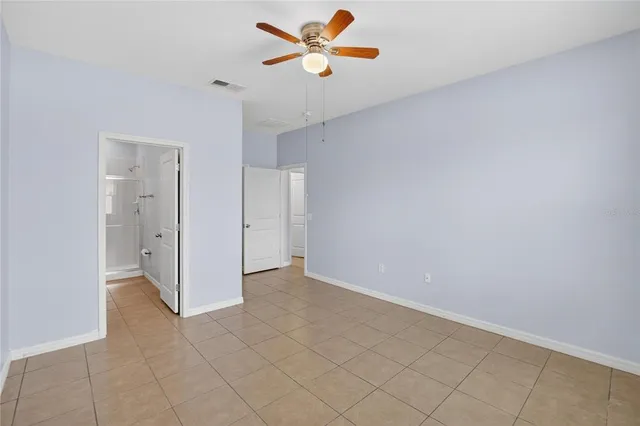 an empty room and chandelier fan