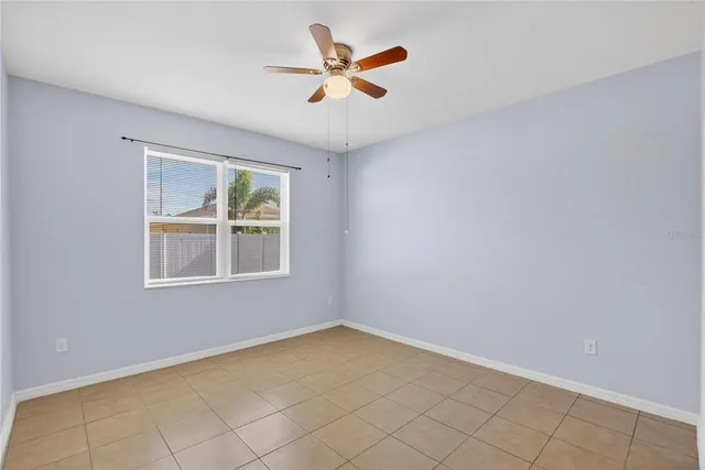 an empty room with window and a ceiling fan