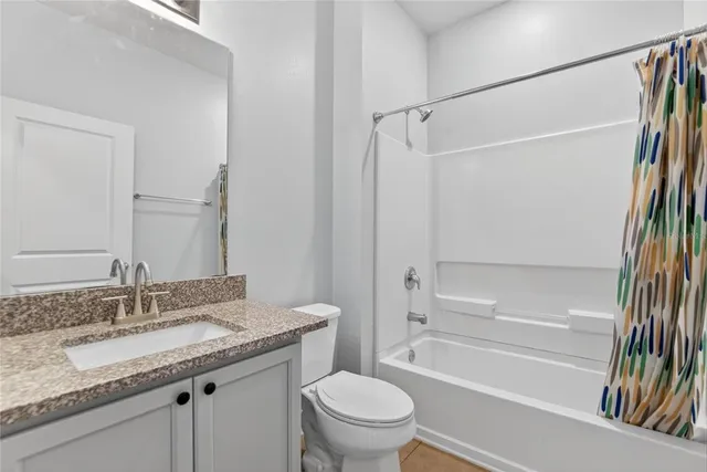 a bathroom with a granite countertop sink a toilet and a mirror