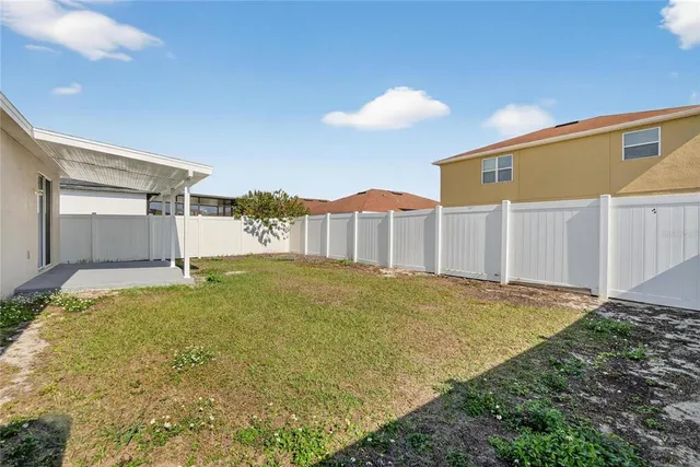 a view of a house with a yard and potted plants