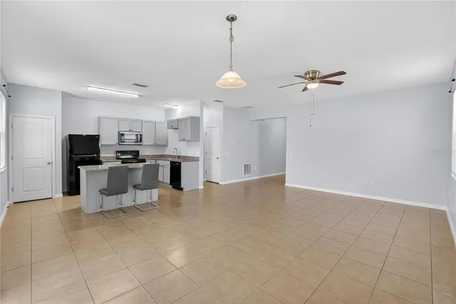 a view of kitchen with refrigerator and microwave