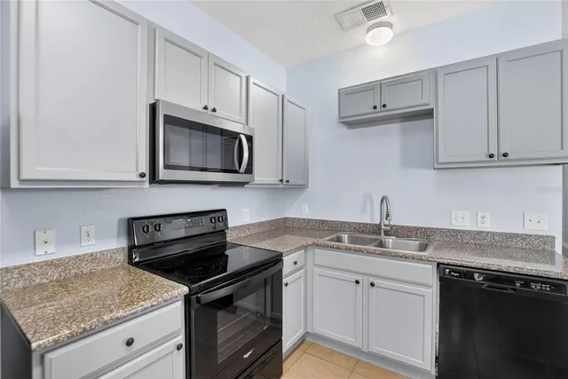 a kitchen with stainless steel appliances granite countertop a sink stove and microwave