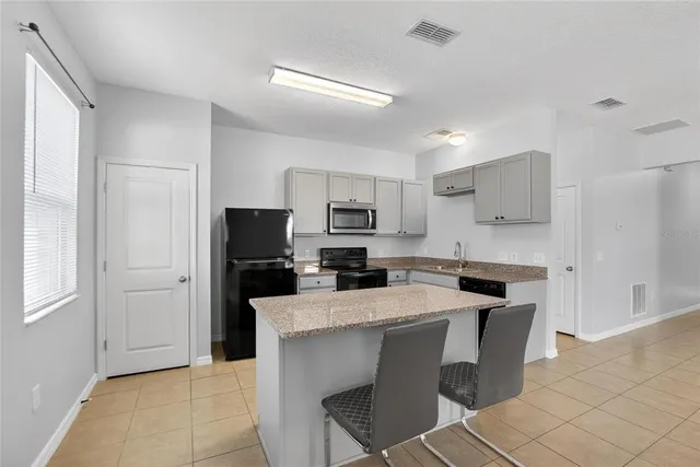 a kitchen with stainless steel appliances a microwave sink and refrigerator